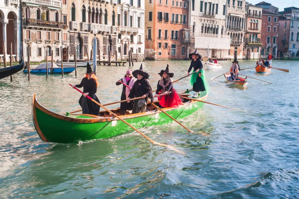 Traditional regatta of Befana in Venice, Italy with witches rowing on the morning of January 6th, also known as Festa della Befana, when she brings presents to children. Festive atmosphere and colorful costumes on the water.